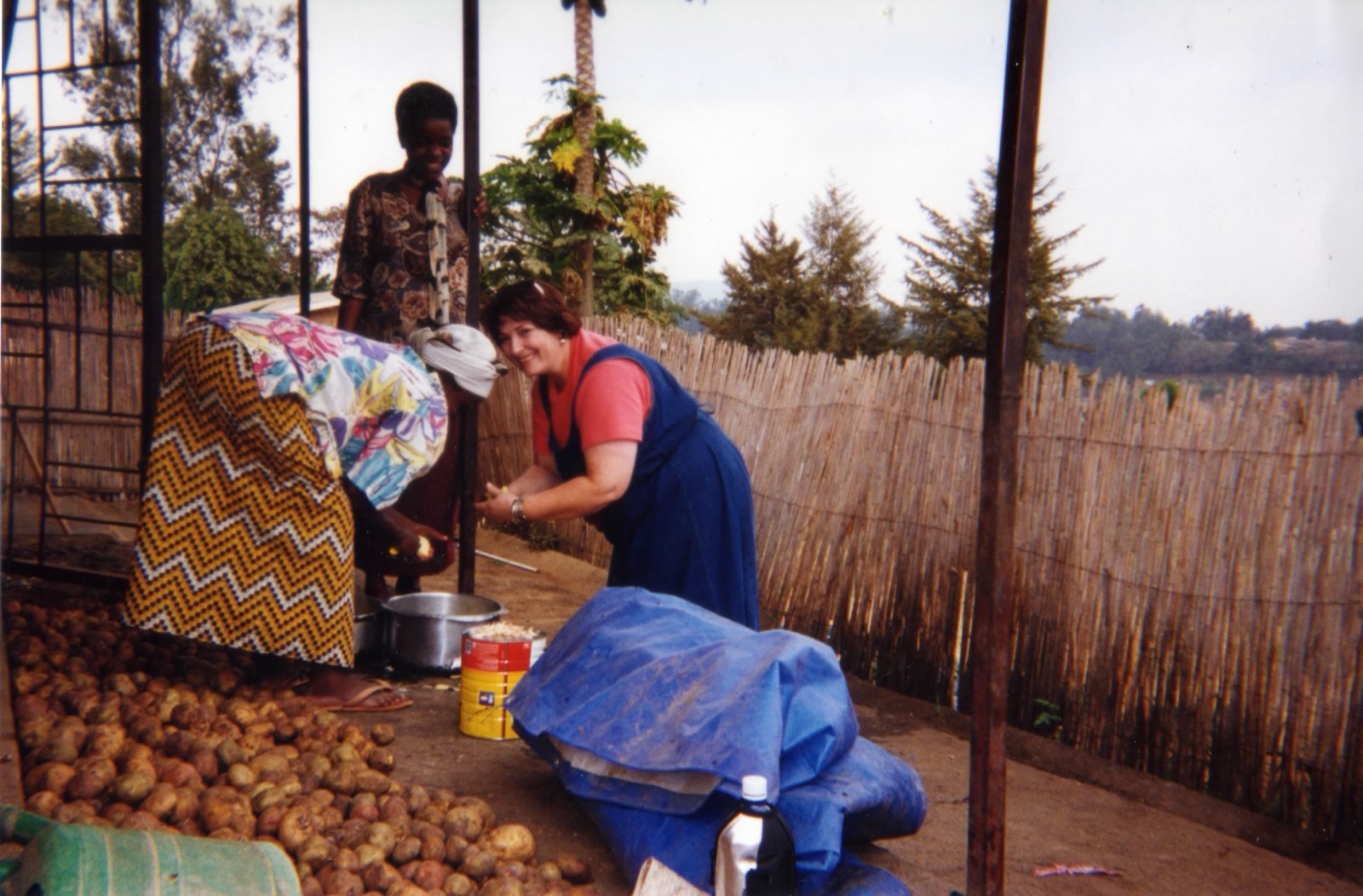 Linda preparing food alongside Rwandan women